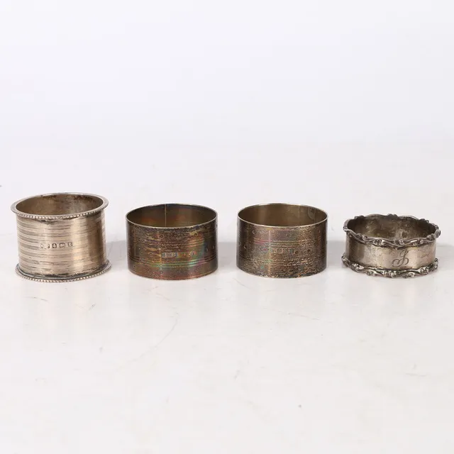 FOUR SILVER NAPKIN RINGS (4).