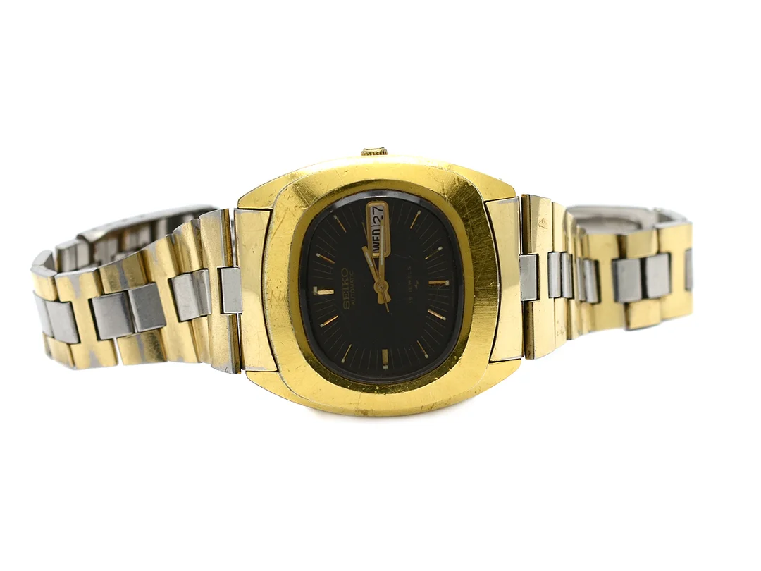 SEIKO, herrur, 39 x 35 mm, Cal 7006, Serie nr. 340507, Boett nr. 7006-5000, bicolour, automatisk, plexiglas, dag, datum, skadad urtavla, defekt, skadad boett, originallänk, viklås (defekt), ca 1973. — Klockor/Seiko — Kaplans