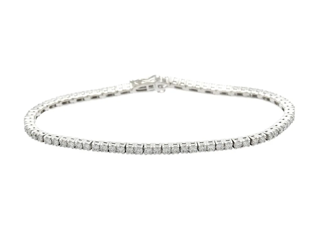 TENNISARMBAND, 18K vitguld, 79 briljantslipade diamanter ca 3,27 ctv ca W/VS, längd 18 cm, vikt 11,0 g. — Smycken/Tennisarmband — Kaplans