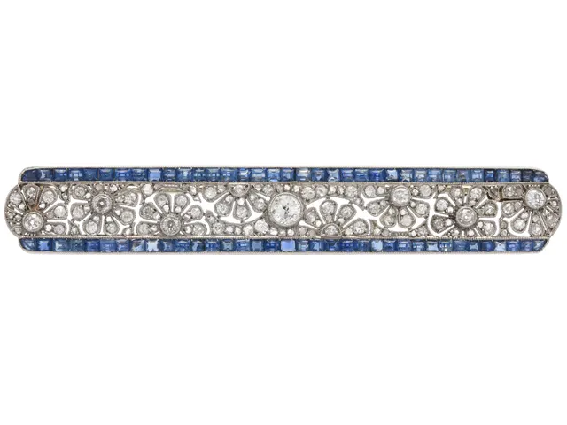 BROSCH, 14K guld/platina, carréslipade safirer, gammal- och rosenslipade diamanter, omkring 1900, fransk kontrollstämpel, 65x22 mm, vikt 9,0 g. några safirer och diamanter med skador och nagg.