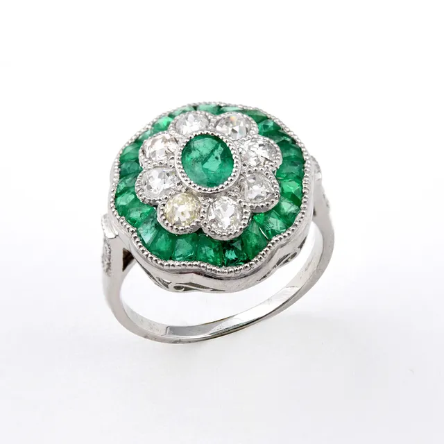 AN EMERALD AND DIAMOND CLUSTER RING.
