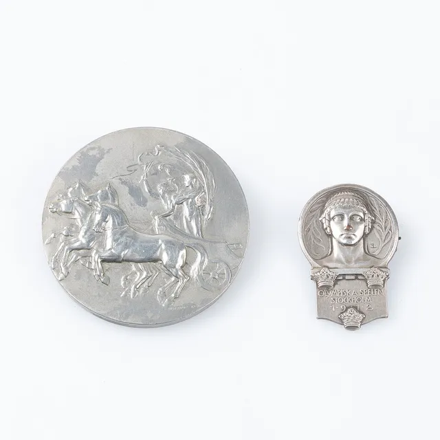 MINNESMEDALJ SAMT PIN, över Olympiska spelen i Stockholm 1912, dekor av Zeus med Stockholm i bakgrunden, formgiven av Erik Lindberg, "Till minne af olympiska spelen i Stockholm 1912".