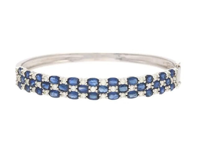 ARMRING, 14K vitguld, blå safirer ca 8,00 ctv, 37 briljantslipade diamanter ca 1,30 ctv, ca W-Cr/VS-P, öppningsbar, 6x5 cm, vikt 17,1 g, ett fåtal safirer och diamanter med nagg.