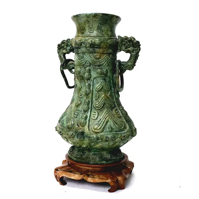 JARRÓN ORIENTAL EN BRONCE PATINADO CON ASAS Y DETALLE DE ARGOLLAS SIGUIENDO LOS MODELOS ARCAICOS, CHINA SIGLO XX. SOBRE BASE DE MADERA.