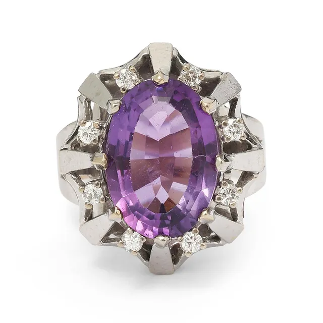 An amethyst and diamond ring set with an oval-cut amethyst and numerous brilliant-cut diamonds, mounted in 14k gold. Weight app. 7 g. W. 20 mm. Size 53.