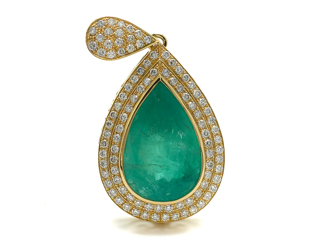 HÄNGE, 18K guld, droppslipad smaragd ca 38,40 ct, ca 95 briljantslipade diamanter ca 3,20 ctv, ca TW-TCR/VS-SI, längd 5,8 cm, vikt 29,3 g, öglan är öppningsbar och behöver spännas så att den stänger, smaragden har sprickor som når ytan, skada och urgröpning, — Smycken/Hänge — Kaplans