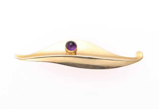 A brooch of 14k set with an amethyst. Weight 4.5 g. Length 7.2 cm.