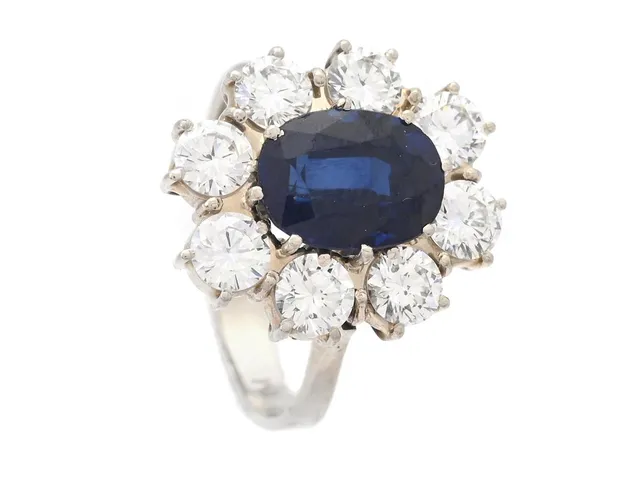CARMOSÉRING, 18K rodinerat guld, ovalslipad syntetisk blå safir ca 2,50 ct, 8 briljantslipade diamanter ca 1,60 ctv, ca TW/VS, stl 17,25 mm, vikt 5,5 g, safir med nagg och skador, en diamant med nagg vid rondisten.