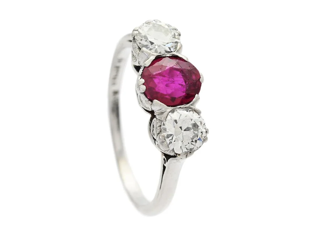 RING, platina, rubin ca 1,35 ct, 2 gammalslipade diamanter ca 0,80 ctv, ca W(H)/VS, stl 17,5 mm, vikt 4,5 g, rubinen inneslutning som når ytan samt slitna fasettkanter. — Smycken/Ring — Kaplans