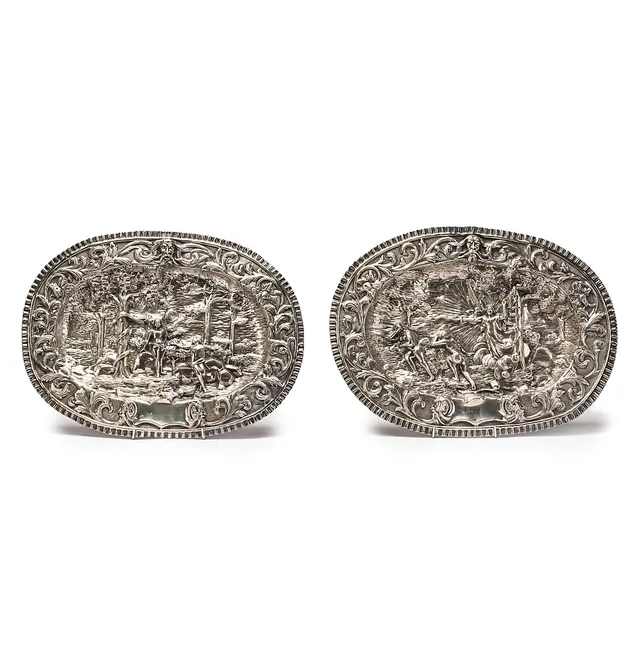 Two Spanish trays in embossed silver decorated with the Original Sin and the Expulsion from Paradise, mid 20th Century.
