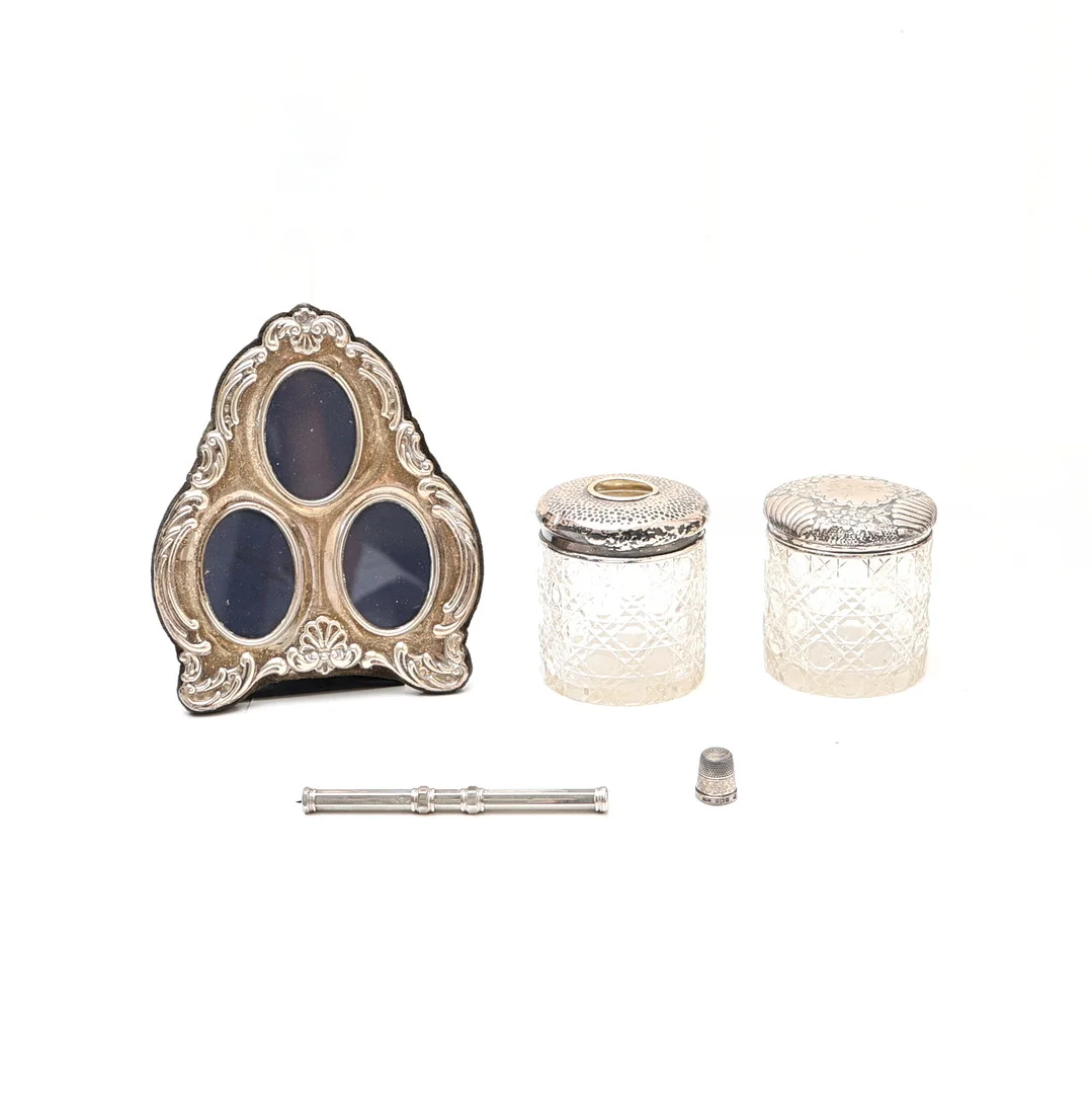 SILVER MOUNTED TRIPLE PHOTOGRAPH FRAME, 2 SILVER TOPPED JARS, AND 2 OTHER ITEMS. (5). — Silver — Young's Auctions