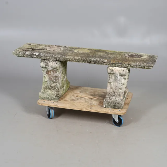A RECONSTITUTED STONE GARDEN BENCH.
