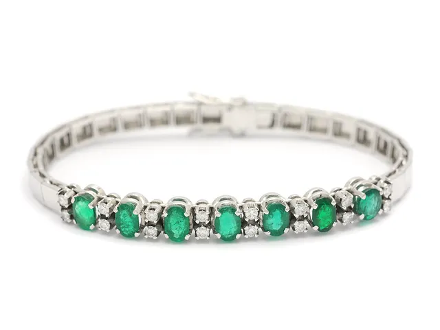 ARMBAND, 18K vitguld, 7 ovalslipade smaragder 3,80 stv enligt gravyr, inneslutningar som når ytan, inverterade naturaler, 16 briljantslipade diamanter 0,53 ctv enligt gravyr, ca W/VS, längd 16,5 cm, vikt 17,0 g.