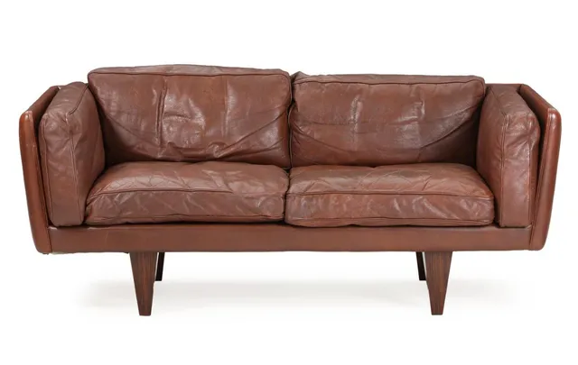 Two seater sofa with rosewood legs, upholstered in sides, back and loose cushions with brown leather. Model V. 17. Manufactured by Holger Christiansen. L. 165 cm.