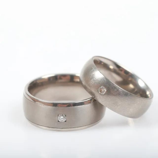 ALLIANSRINGAR, 2 stycken, titan med briljantslipade diamanter, totalt 0,06 ct.