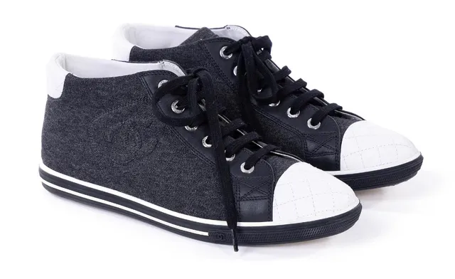 A pair of sneakers of dark grey fabric and black and white leather with black laces, a white and black rubber sole and white leather inside. Size 36 ½. (2)