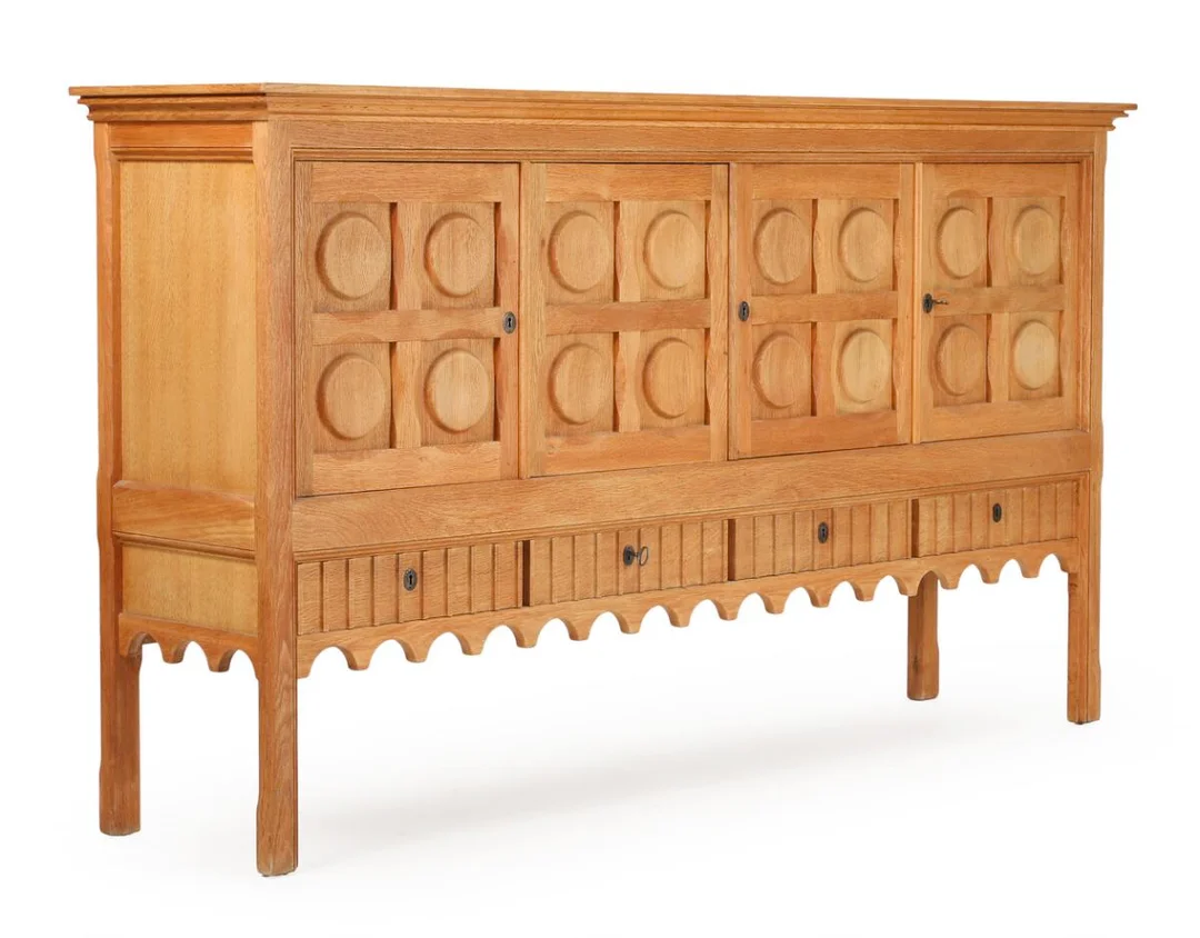 A patinated oak sideboard with carvings, front with four drawers and four doors, behind which shelves. Manufactured and marked by Nyrup Møbelfabrik. 1970s. H. 120.5. W. 212. D. 50 cm. — Modern Furniture — Bruun Rasmussen