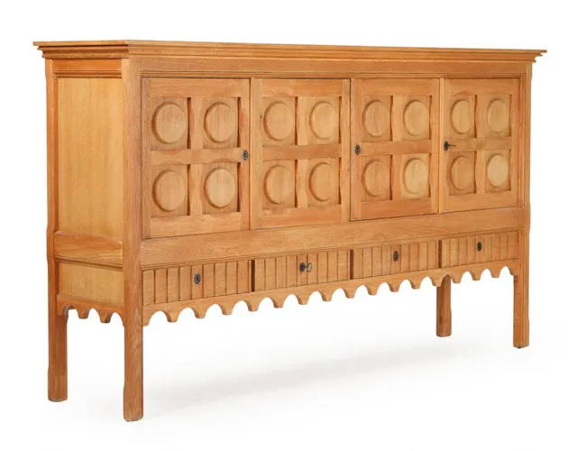 A patinated oak sideboard with carvings, front with four drawers and four doors, behind which shelves. Manufactured and marked by Nyrup Møbelfabrik. 1970s. H. 120.5. W. 212. D. 50 cm.