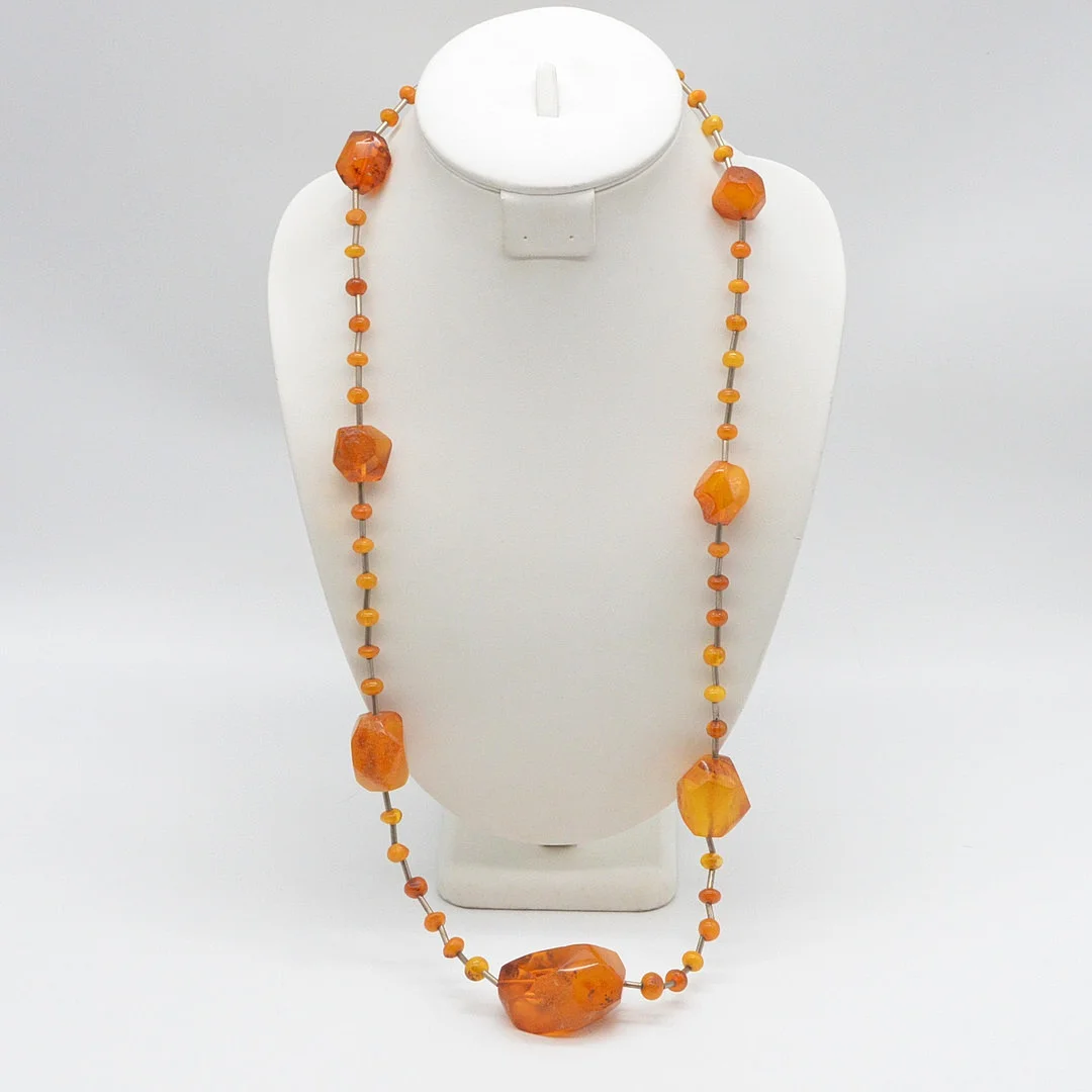 COLLIER MIT GROSSEN PERLEN AUS BERNSTEIN, BALTIC BUTTERSCOTCH, TRENNPERLEN IN STÄBCHENFORM, VERSCHLUSS AUS BERNSTEIN, UM 1950, CA. 82 CM. — Necklace — Kunst- und Auktionshaus Kleinhenz