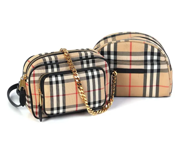 A “Camera” bag of light brown checkered canvas with black leather trimmings, gold tone hardware, adjustable shoulder strap, two zipped compartments, an interior pocket and black lining, as well as a matching toiletry pouch with an exterior pocket, two interior pockets and black lining. H. 14 x W. 19 x D. 9 cm and H. 15 x W. 21 x D. 8 cm. (2)