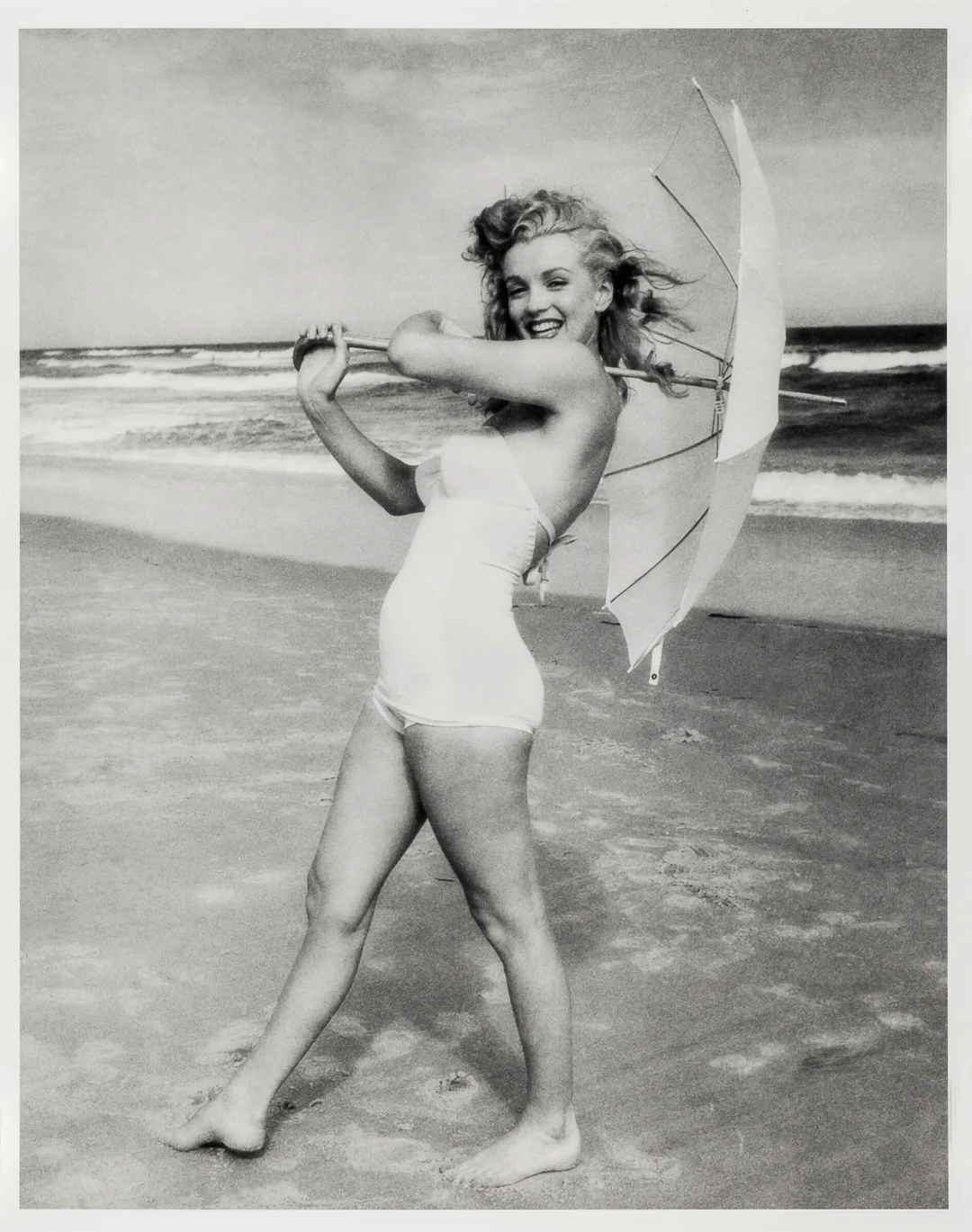 Dienes, Andre de — Marilyn Monroe i badedrakt og parasoll på stranden — Kunst/Fotografi — Blomqvist