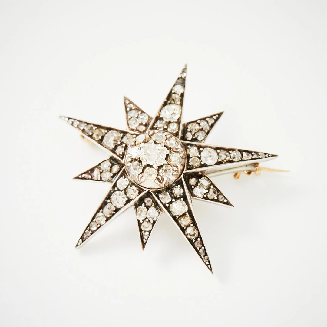 BROSCH, guld och silver, i form av en stjärna, s.k. celestial jewellery, dekor av totalt 72 diamanter med antik-, cushion- och rosenslipning, 1800-talets andra hälft. — Brooches & Pendants — Stockholms Auktionsverk Magasin 5