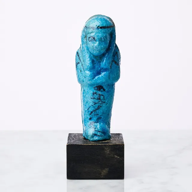 USHABTI, Egypten, Tredje mellanperioden, 21-22 dynastin, 1069-943, fajans med blå glasyr, monterad på sockel i trä.