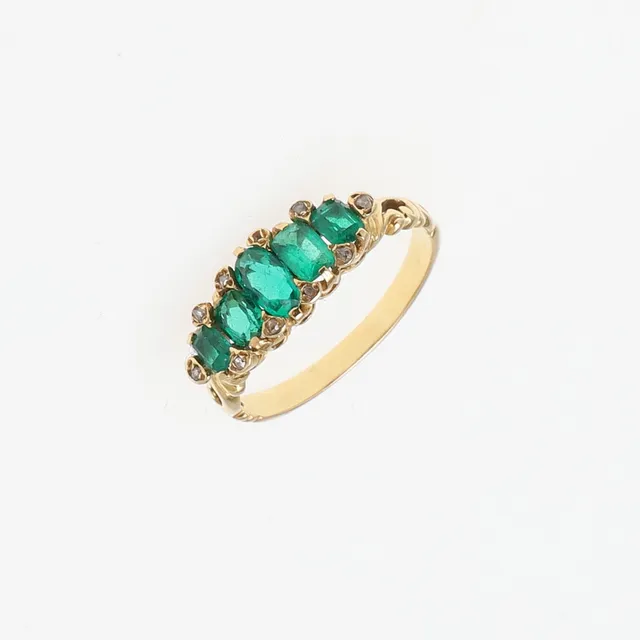 AN EMERALD AND DIAMOND FIVE STONE RING.
