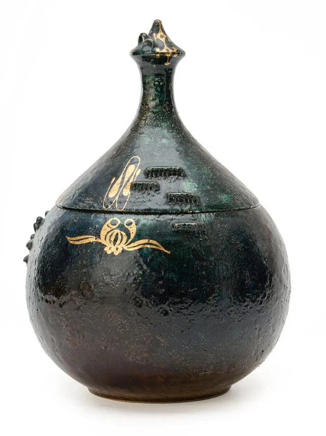 Onion-shaped earthenware lid jar modelled with relief motifs and patterns. Decorated with dark blue-green glaze with gilt motifs. Signed Bjørn Wiinblad. H. 30 cm. Diam. max. 20 cm.