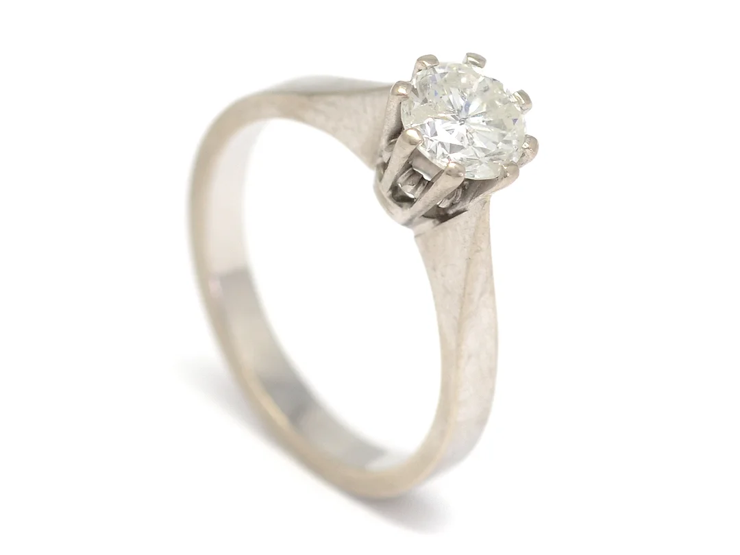 ENSTENSRING, 18K vitguld, briljant 0,96 ct enl gravyr, ca TCr/P1, diameter 6,01X6,29 mm, stort bord, låg krona, stl 17,5 mm, vikt 4,7 g, Kå-ce Guldmsedja, Stockholm 1977. — Smycken/Enstensring — Kaplans