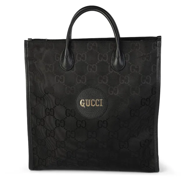 An “Off the Grid” tote bag of black monogram canvas and leather with silver tone hardware, two handles, detachable and adjustable shoulder strap, one compartment with two interior zipped pockets and black fabric lining. H. 36 x W. 36 x D. 12 cm.