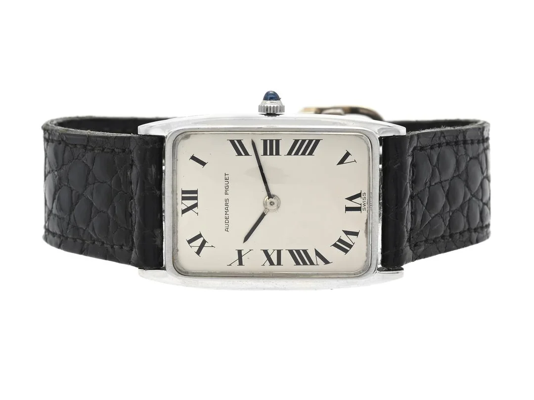 AUDEMARS PIGUET, herrur, 22,5 x 27 (34) mm, Cal 2003, Serie nr. 102195, Boett nr. 46678, 18K vitguld, manuell, safirglas (nagg), målade visare, skadad urtavla, defekt (går ej, akut servicebehov, se fördjupad info), läderband, viklås i 18K vitguld, ca 1967. — Klockor/Audemars Piguet — Kaplans