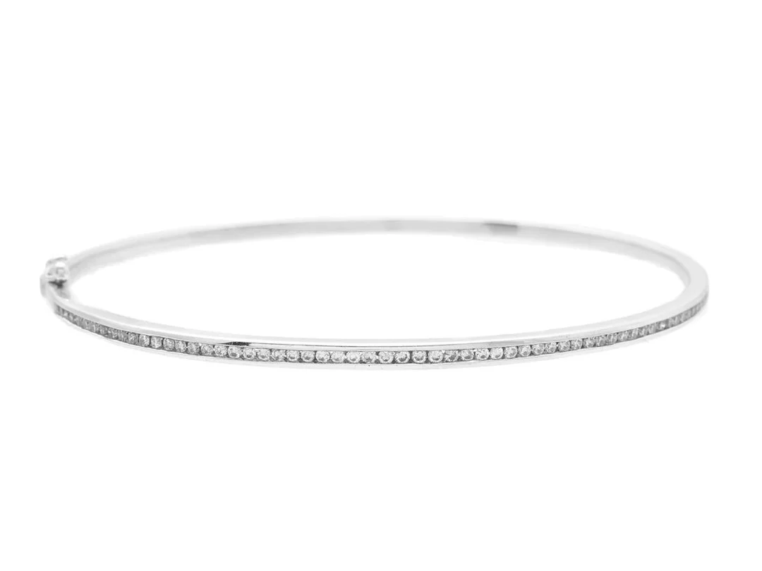 ARMRING, 18K vitguld, briljantslipade diamanter ca 0,60 ctv, ca W/SI, innermått ca 60,0 x 52,0 mm, vikt 8,7 g. — Smycken/Armring — Kaplans