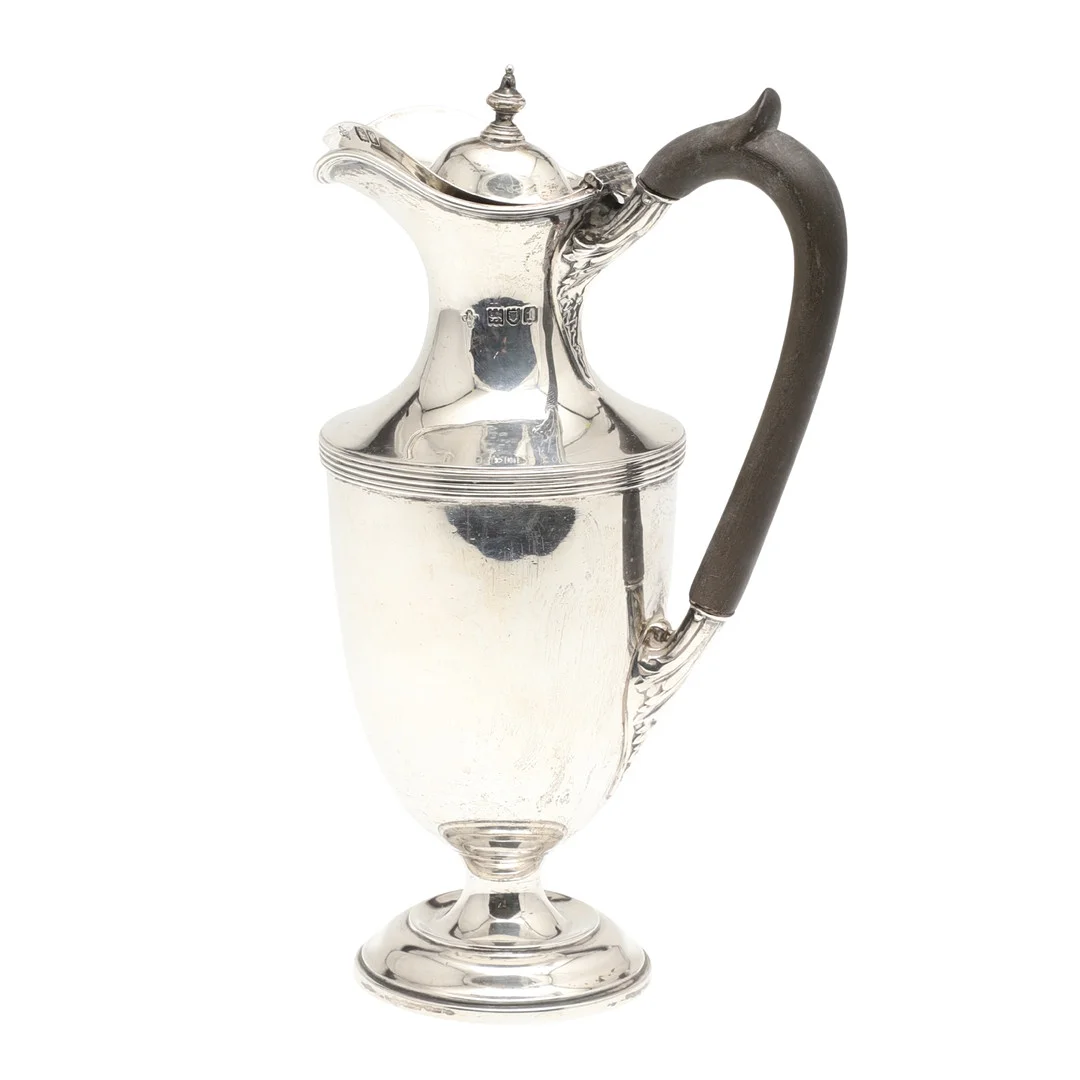 AN EDWARDIAN SILVER HOT WATER JUG. — Silver — Lawrences Auctioneers