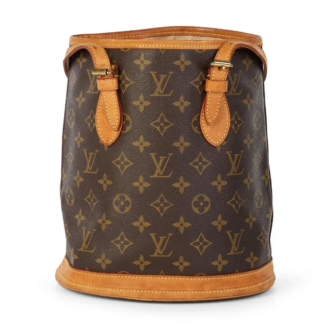 A “Bucket PM” bag of brown monogram canvas with brown leather trimmings, gold tone hardware, two adjustble handles, one open compartment, two interior pockets, one of which has a zipper, and beige interior lining.. H. 26 x W. 23 x D. 16 cm. 2001.
