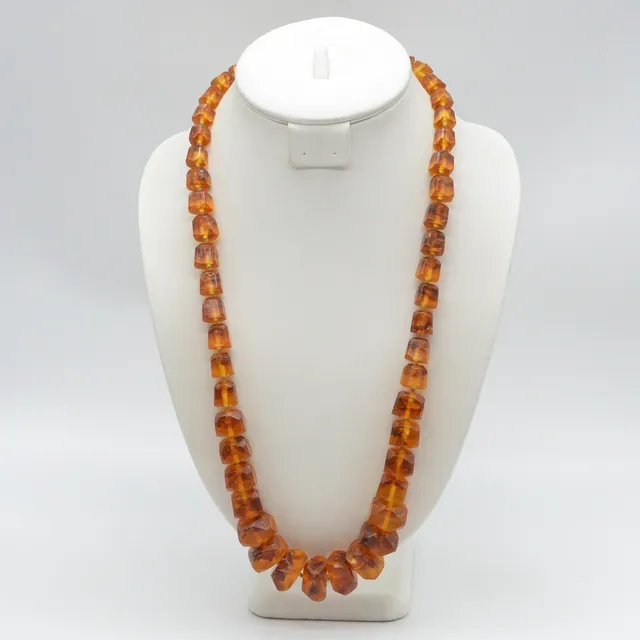 LANGES COLLIER AUS BERNSTEIN, MIT EINSCHLÜSSE, IN FORM GESCHNITTEN, ENDLOS, UM 1950.