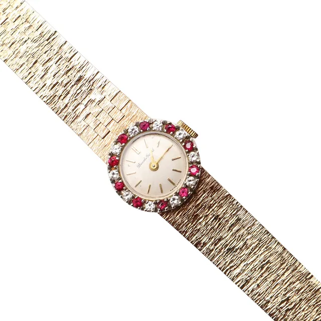 A LADY'S GOLD, RUBY AND DIAMOND WRISTWATCH BY BUECHE GIROD.