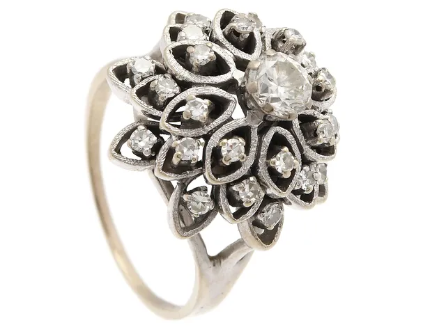 RING, 18K vitguld, briljantslipad diamant ca 0,60 ct, 24 åttkantslipade diamanter ca 0,72 ctv, ca W-Cr/VS, stl 20,75 mm, vikt 12,9 g, mittstenen med skada på rondisten, några av de mindre stenarna är skadade, en sten sitter snett i sin fattning, slitna klor.