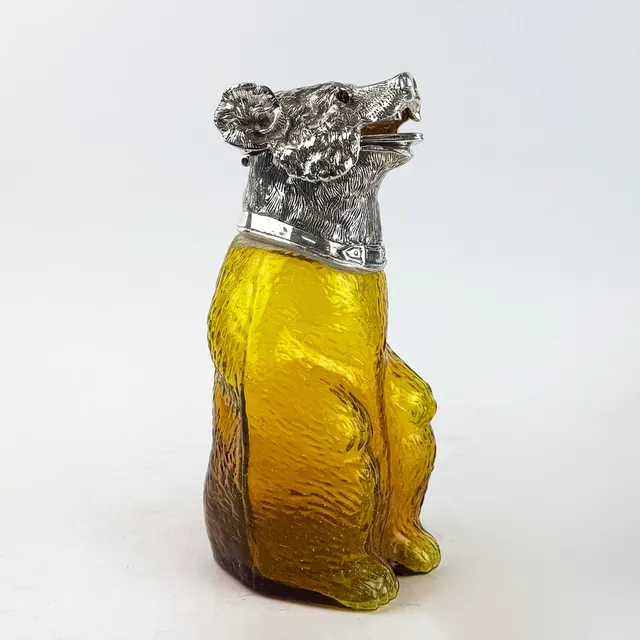 POLISHED METAL AND YELLOW GLASS BEAR CLARET JUG.