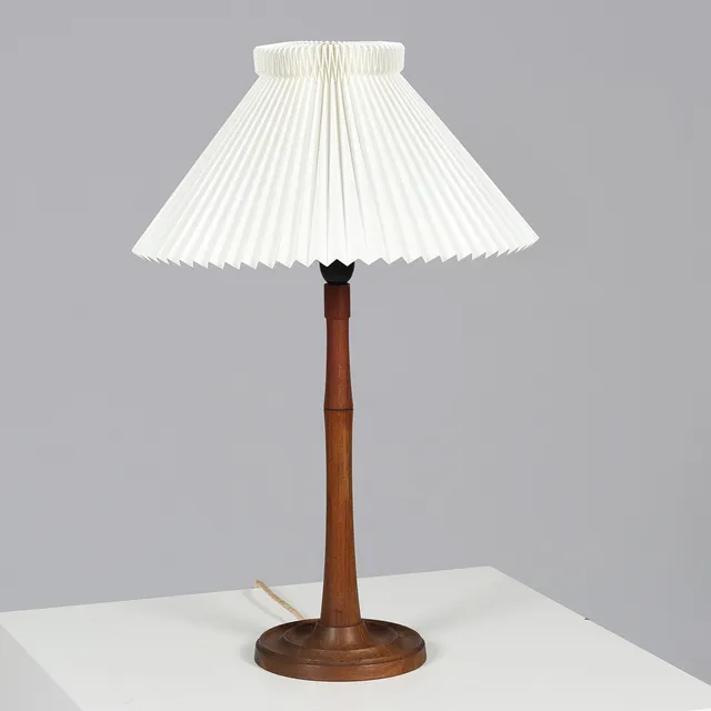Bordlampe drejet i massivt teaktræ med plisseret skærm fra Le Klint, dansk lampeproducent, 1900-tallets midte.