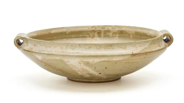Stoneware bowl modelled with two small handles. Decorated with light greyish-green glaze. Signed monogram, 3524. Unique. Royal Copenhagen. H. 7 cm. Diam. incl. handles 22.7 cm.