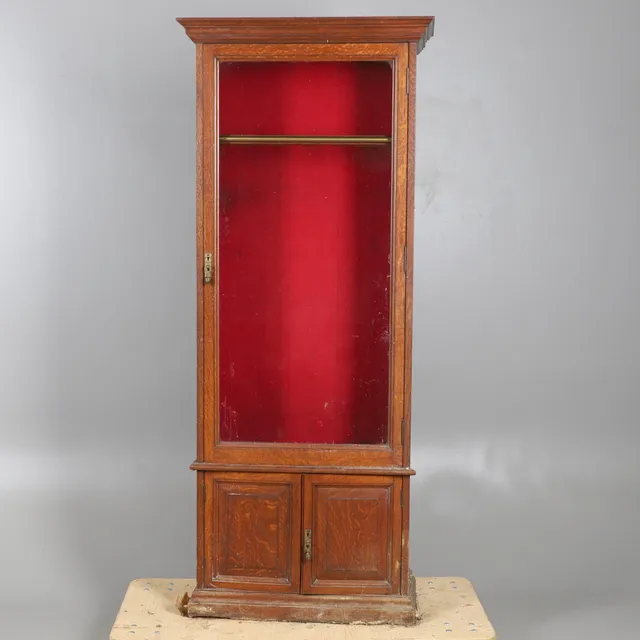 AN OAK GUN CABINET.
