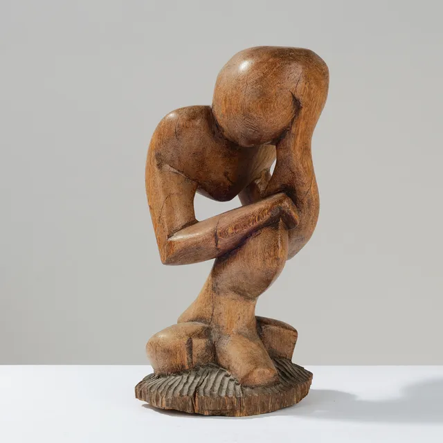 Skulptur udskåret af massivt træ forestillende tænkende skikkelse med abstrakt form.