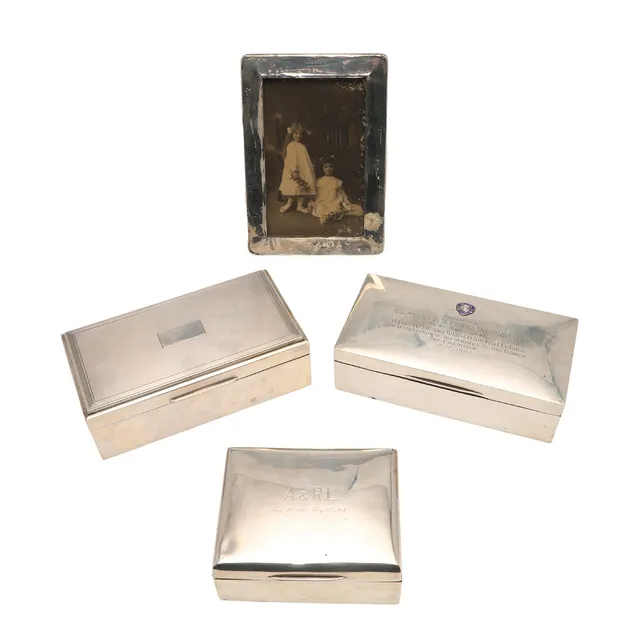 THREE SILVER CIGARETTE BOXES & A MOUNTED PHOTOGRAPH FRAME.