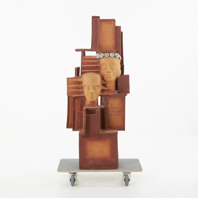 JOSEF SIMON (FÖDD 1934). skulptur, figurkomposition, keramik, delvis glaserad och bemålad, signerad och daterad 1994, med texten "Vi sköter om människor och hus".
