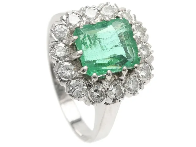 CARMOSÈRING, 18K vitguld, smaragd 2,70 ct, 14 briljantslipade diamanter 0,95 ctv, ca TW/VVS-VS, Göteborg 1973, stl 18,75 mm, vikt 8,1 g, smaragden har nagg och mindre skador på fasettkanterna, en diamant har mindre skada.