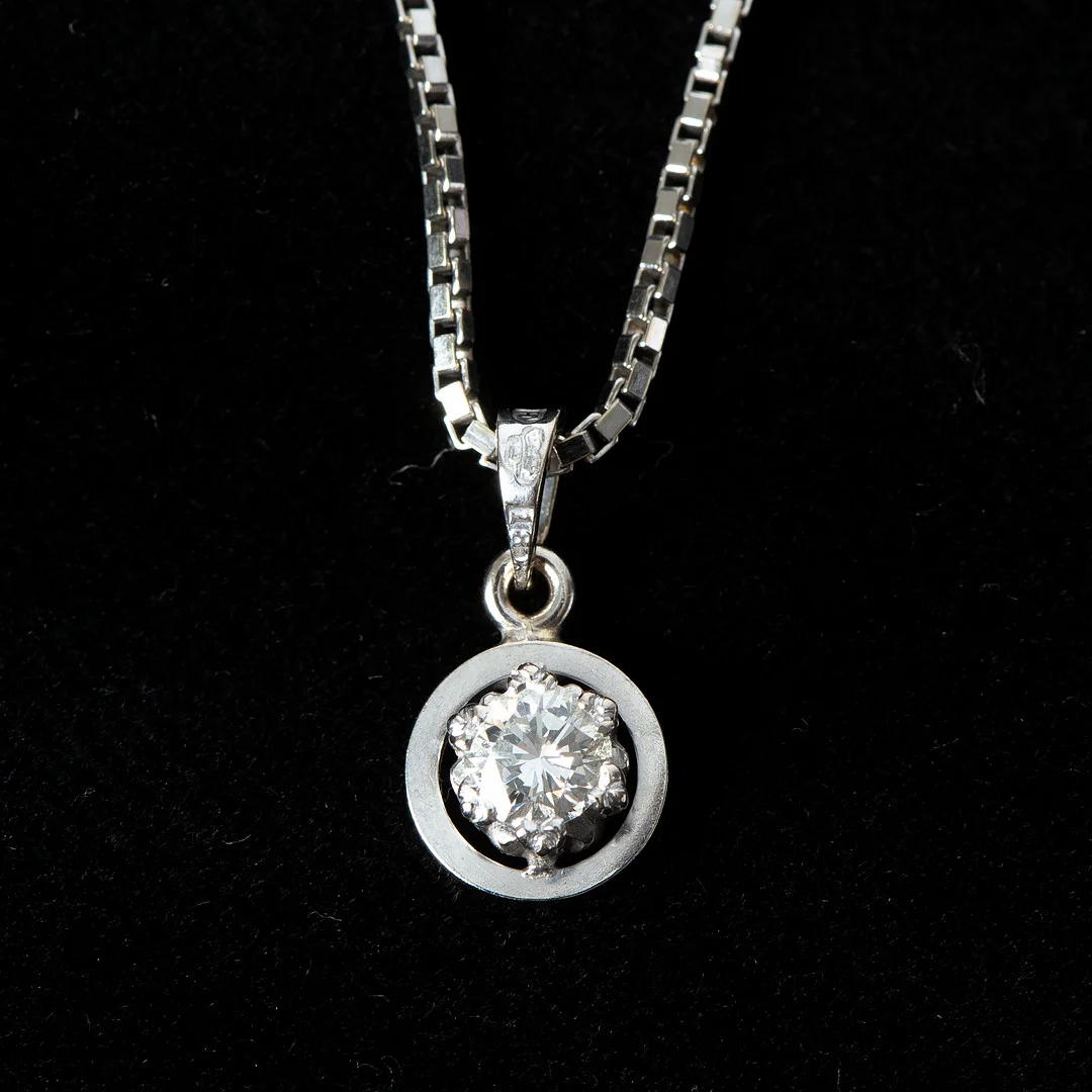 HÄNGE, 18K vituguld med briljantslipad diamant 0.32 ct, Alton, Falköping. — Brooches & Pendants — Stockholms Auktionsverk Göteborg