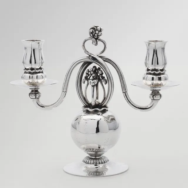 GEORG JENSEN (1866-1935). To armet kandelaber af hammerslået sterling sølv, dateret 1933.