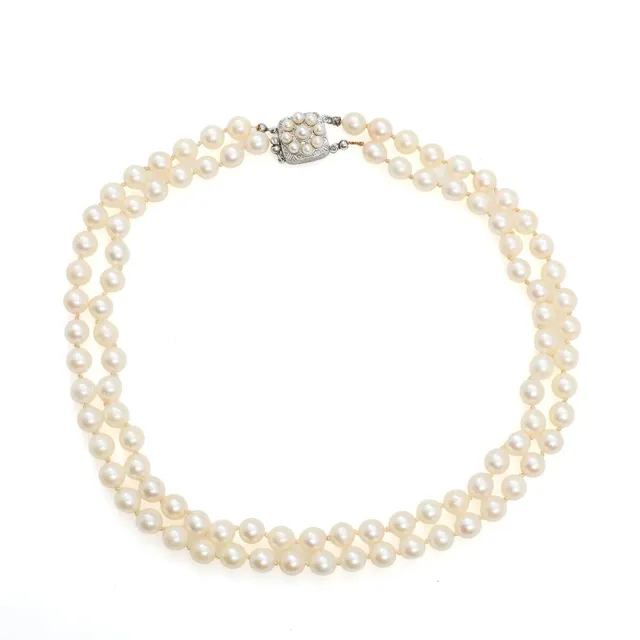A two-strand pearl necklace set with numerous cultured pearls, mounted with silver clasp. L. 42 cm.