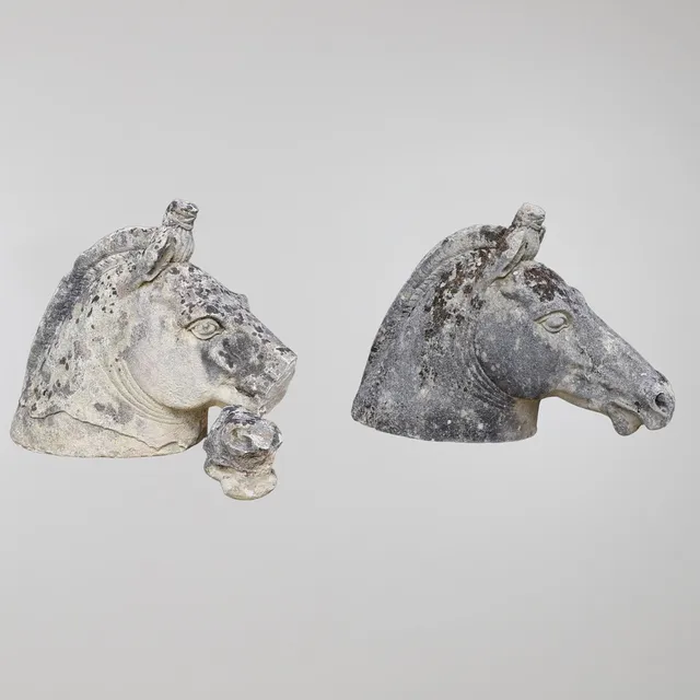 A PAIR OF CARVED SANDSTONE ROMAN HORSE'S HEAD FINIALS.